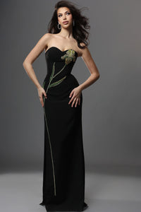 Woman wearing a black strapless gown with floral embellishments on a gray background