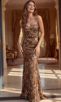 A woman wearing a strapless, floor-length bronze sequined gown with floral embroidery, standing in a grand, sunlit room with gold drapery.