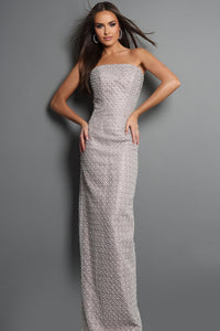 A woman modeling a strapless, floor-length gown with a textured, woven pattern in light gray and white, set against a solid gray studio background.