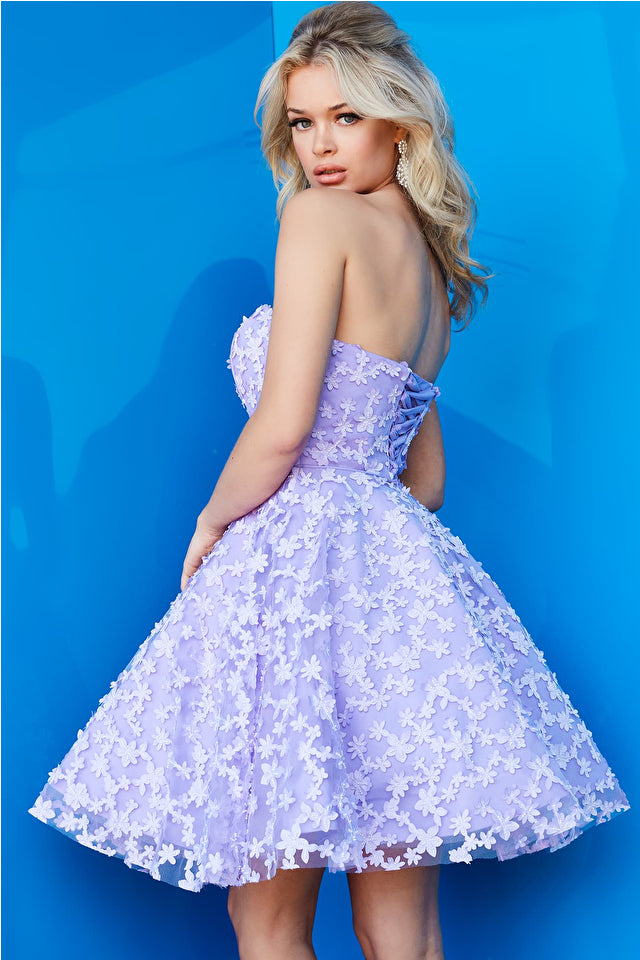 A strapless fit and flare dress with floral appliques, ideal for Bat Mitzvahs, graduations, and homecoming events. Model is wearing the dress in lilac.