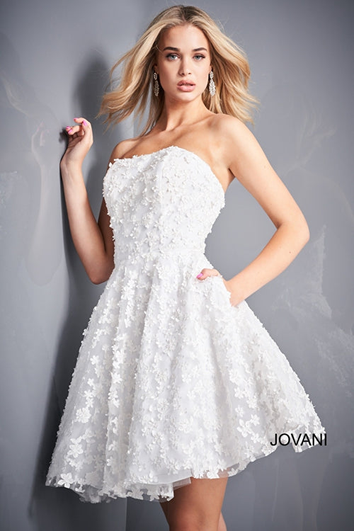 A strapless fit and flare dress with floral appliques, ideal for Bat Mitzvahs, graduations, and homecoming events.  Model is wearing the dress in white.