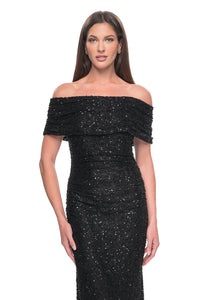 La Femme 31778 Elegant Off-the-Shoulder Lace Evening Gown - A fitted and elegant long dress adorned with exquisite beaded lace, featuring an off-the-shoulder neckline and meticulous ruching.  The model is wearing the dress in the color black.