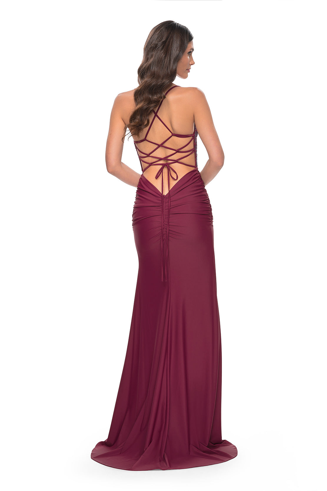 La Femme 31988 Rhinestone Embellished Lace Bodice Prom Gown - A glamorous long dress featuring a ruched jersey skirt, high slit, rhinestone embellished lace bodice with exposed boning, lace-up back, and ruching along the zipper for a perfect fit. The model is wearing the dress in dark Berry. back view,