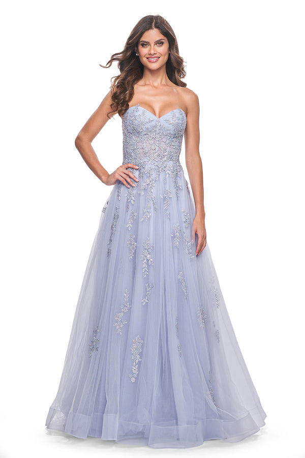 La Femme 32084 A-Line Prom and Quinceañera Gown with Lace Applique - An enchanting A-line gown featuring delicate ruched detail, a lace-up bodice, sweetheart neckline, and intricate lace applique for a statement look at prom or quinceañera celebrations. The dress in the picture is light periwinkle.