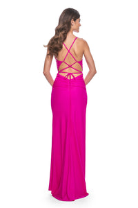 La Femme 32152 Ruched Jersey Prom Dress - Elevate your prom look with this meticulously ruched jersey gown featuring a gracefully draped neckline, an alluring open lace-up back, and a high slit for added glamour.  The model is wearing the dress in the color hot fuchsia.