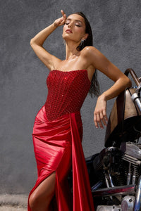 Model wearing Ladivine C170 strapless gown in the color red with rhinestone bodice and a high-slit draped skirt.  Close up view of the dress.