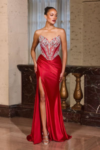 Woman in a red evening gown with intricate top design in a marble hallway.