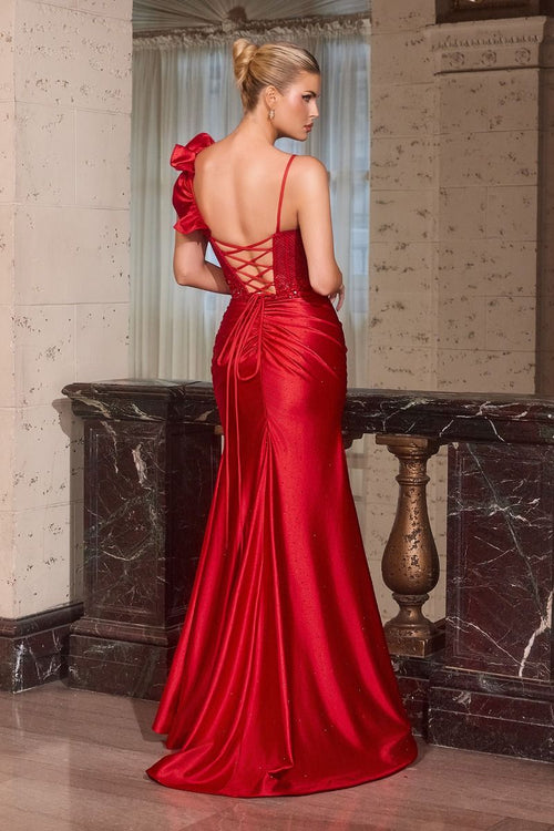 Woman in a red evening gown standing in an elegant interior setting.
