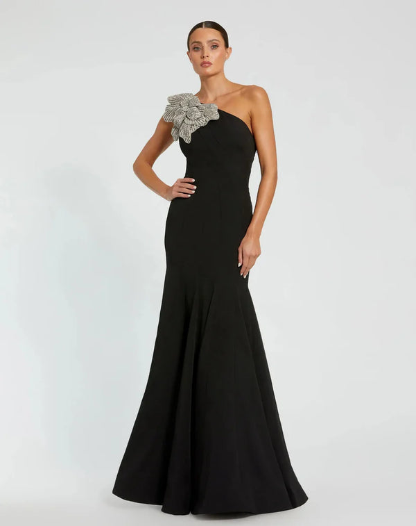 Model wearing Mac Duggal 11810 one-shoulder trumpet gown with flower detail.  Model wearing the dress in the color black.  Front view.