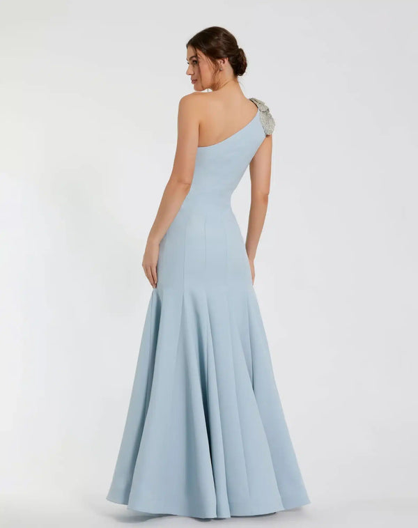 Model wearing Mac Duggal 11810 one-shoulder trumpet gown with flower detail.  Model wearing the dress in the color powder blue.  Back view.
