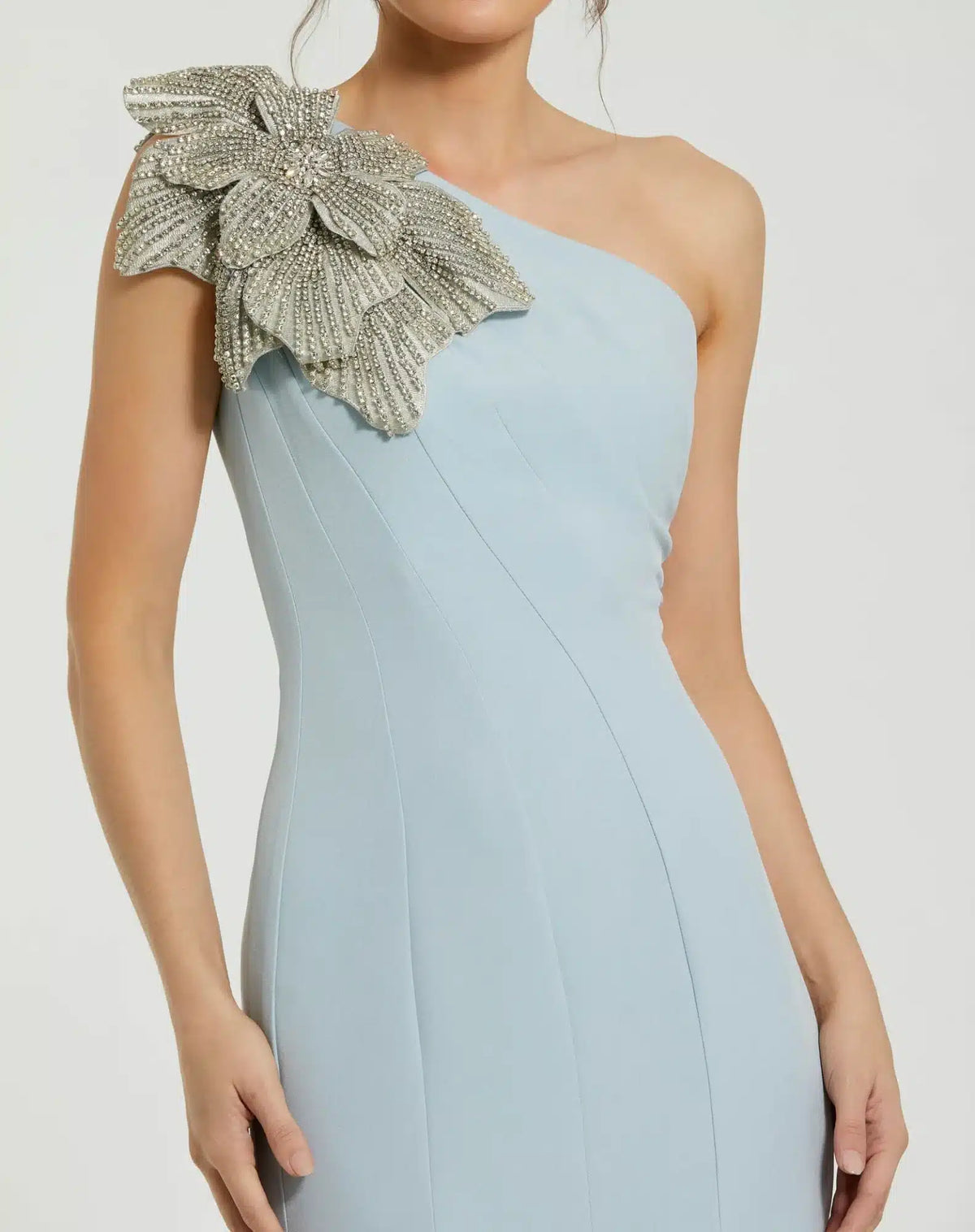 Model wearing Mac Duggal 11810 one-shoulder trumpet gown with flower detail.  Model wearing the dress in the color powder blue.  Close up