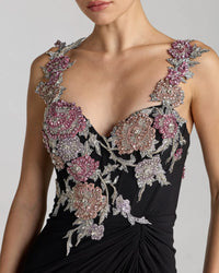 Black evening gown with floral and bead embellishments on a plain background