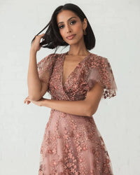 Model wearing Mac Duggal 20486 gown with faux wrap v-neckline, flutter sleeves, and rhinestone floral embellishments.