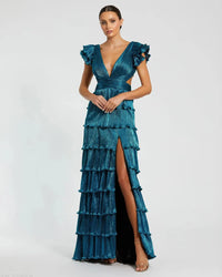 Model wearing Mac Duggal 26740 gown with deep V-neckline, ruffled sleeves, tiered pleated skirt, lace-up back, and thigh-high slit.  Model is wearing the color blue.  Front view.
