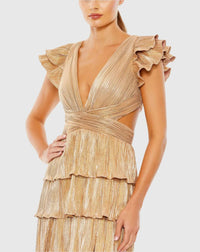 Model wearing Mac Duggal 26740 gown with deep V-neckline, ruffled sleeves, tiered pleated skirt, lace-up back, and thigh-high slit.  Model is wearing the color gold.  Close up of dress.