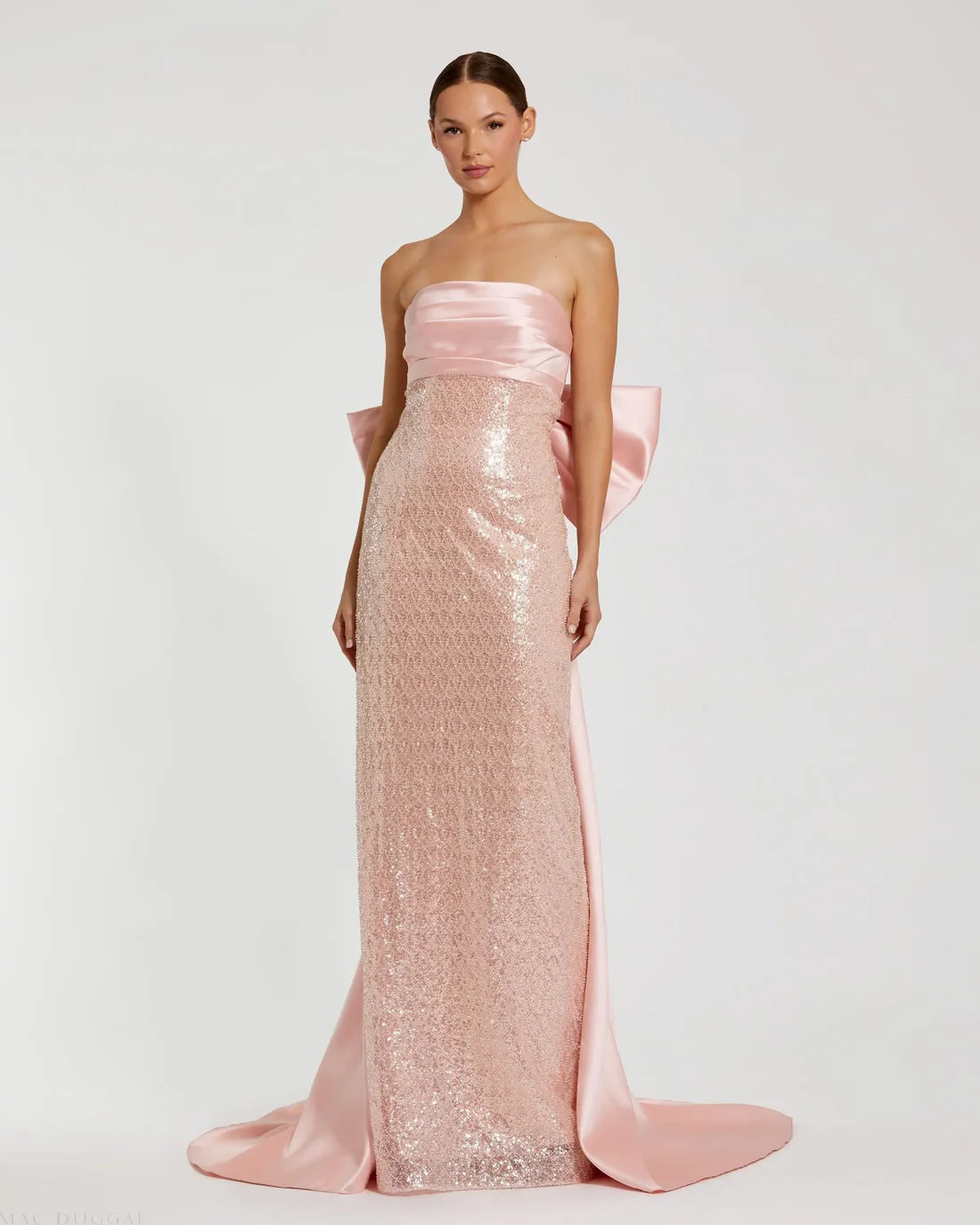 Model wearing Mac Duggal 37011 strapless gown featuring a sleek silhouette with an oversized bow detail on the back.  Front view.  Model wearing the color blush.