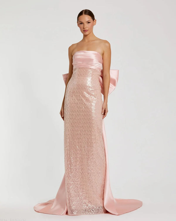 Model wearing Mac Duggal 37011 strapless gown featuring a sleek silhouette with an oversized bow detail on the back.  Front view.  Model wearing the color blush.
