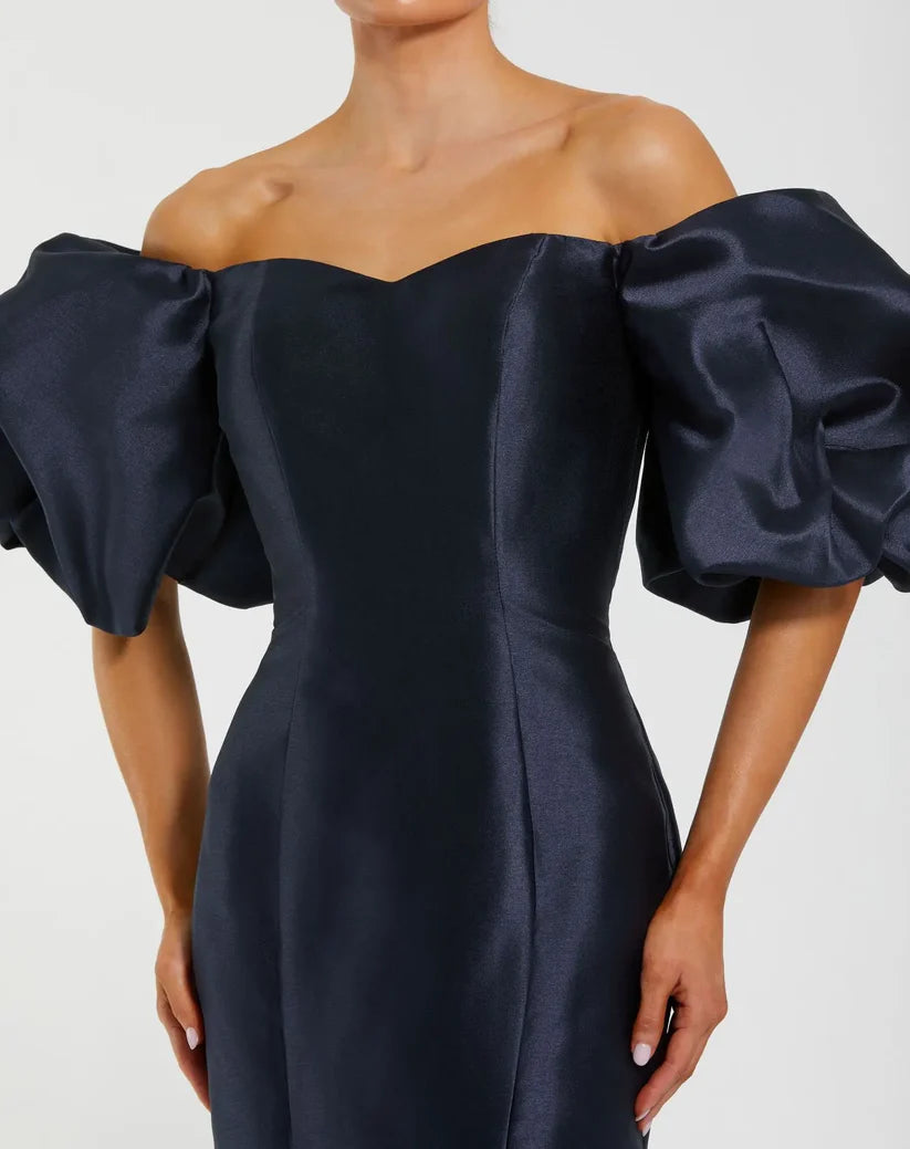 Model wearing Mac Duggal 50677 off-the-shoulder satin gown with puff sleeves, mermaid silhouette, and sweeping train.  Model is wearing the color midnight. Front view. Close Up.