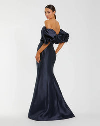Model wearing Mac Duggal 50677 off-the-shoulder satin gown with puff sleeves, mermaid silhouette, and sweeping train.  Model is wearing the color midnight. 3/4 Front view.