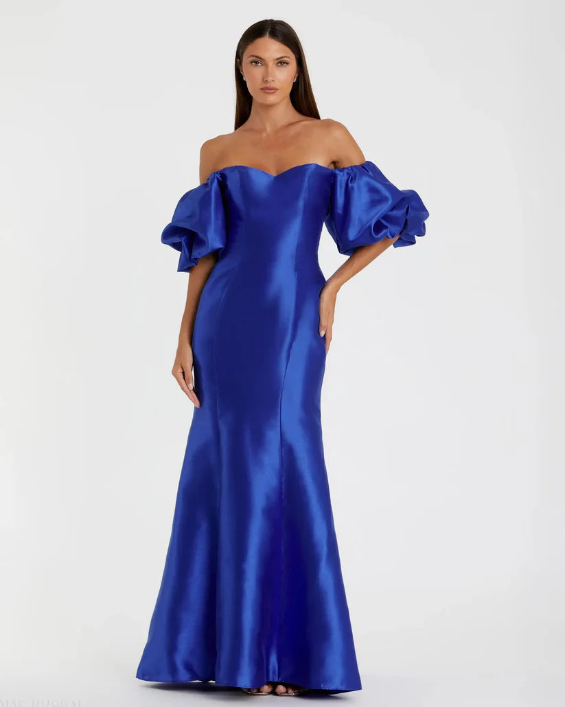 Model wearing Mac Duggal 50677 off-the-shoulder satin gown with puff sleeves, mermaid silhouette, and sweeping train.  Model is wearing the color royal blue. Front view.