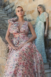 Model wearing Mac Duggal 68947 floral chiffon ballgown with plunging V-neckline, ruffle shoulder detail, and voluminous A-line skirt.  Model is wearing the dress in pinkMulti.  Front view.  Model in the back is wearing 5640 in seafoam.