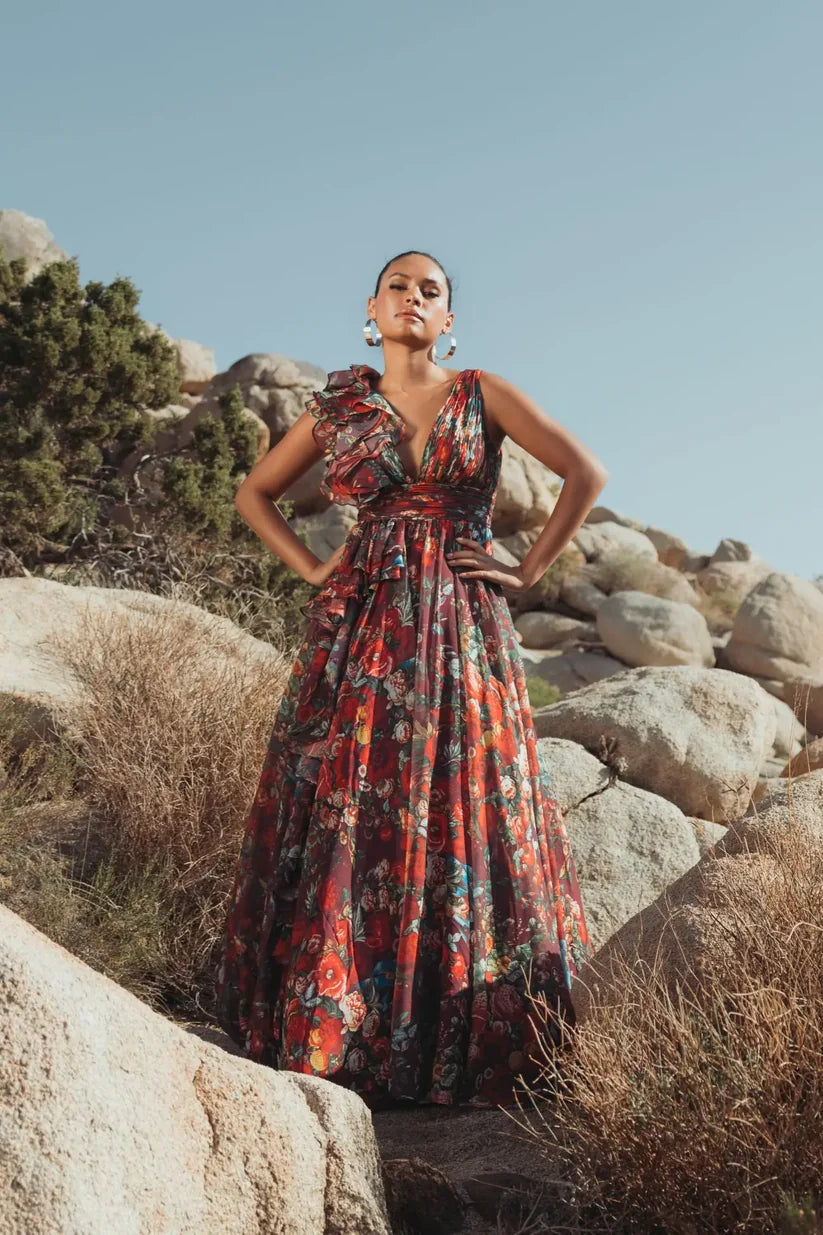 Model wearing Mac Duggal 68947 floral chiffon ballgown with plunging V-neckline, ruffle shoulder detail, and voluminous A-line skirt.  Model is wearing the dress in wine multi.  Front view.