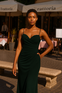 Model wearing the Madeline’s Bella gown with beaded bodice, spaghetti straps, and ruched fitted skirt in navy and emerald green.