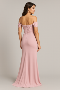 Model wearing Madeline’s Catherine off-shoulder beaded gown with ruched bodice and floor-length skirt.  The model is wearing the color Pink.  Back view.