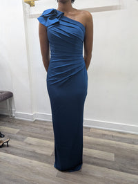 Model wearing the Madeline’s Chloe one-shoulder floor-length gown with ruched detailing and a statement ruffle shoulder.