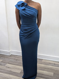 Model wearing the Madeline’s Chloe one-shoulder floor-length gown with ruched detailing and a statement ruffle shoulder.