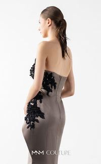 Model wearing the MNM Couture G2045 strapless sculpted evening gown featuring intricate bodice detailing and an asymmetrical floor-length silhouette.
