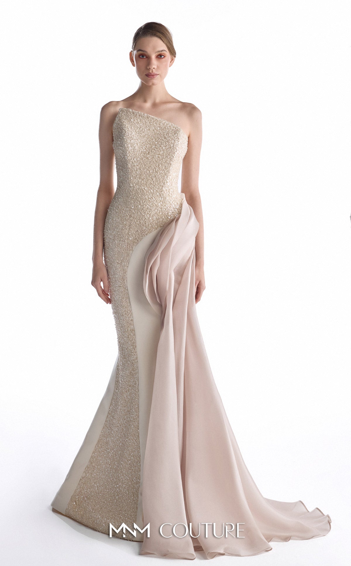 A model wears a one-shoulder evening gown with a textured champagne-beige sequined bodice and a flowing blush pink chiffon skirt overlay, set against a plain white studio background.
