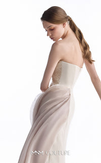 A woman modeling a strapless ivory wedding gown with a beaded bodice and flowing skirt, photographed against a clean white background. The brand name 'MM COUTURE' is visible at the bottom.