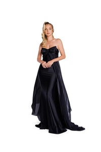 Model wearing Nicole Bakti 7388 gown featuring a strapless bow bodice and chiffon overlay