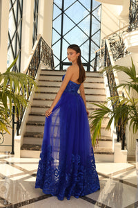 Nicoletta NC1003 Elegant Strapless Evening Dress - A captivating full-length gown with a sweetheart neckline, featuring a removable tulle skirt overlay adorned with Lace Applique for a touch of glamour. This is a picture of the back of the dress in the color Royal.