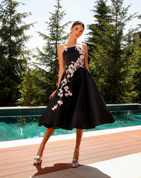 Model wearing Nicoletta NC2079 strapless navy and black A-line dress with floral appliqué and full midi skirt.
