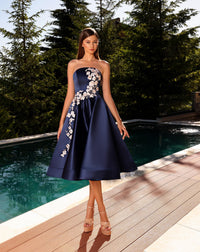 Model wearing Nicoletta NC2079 strapless navy and black A-line dress with floral appliqué and full midi skirt.