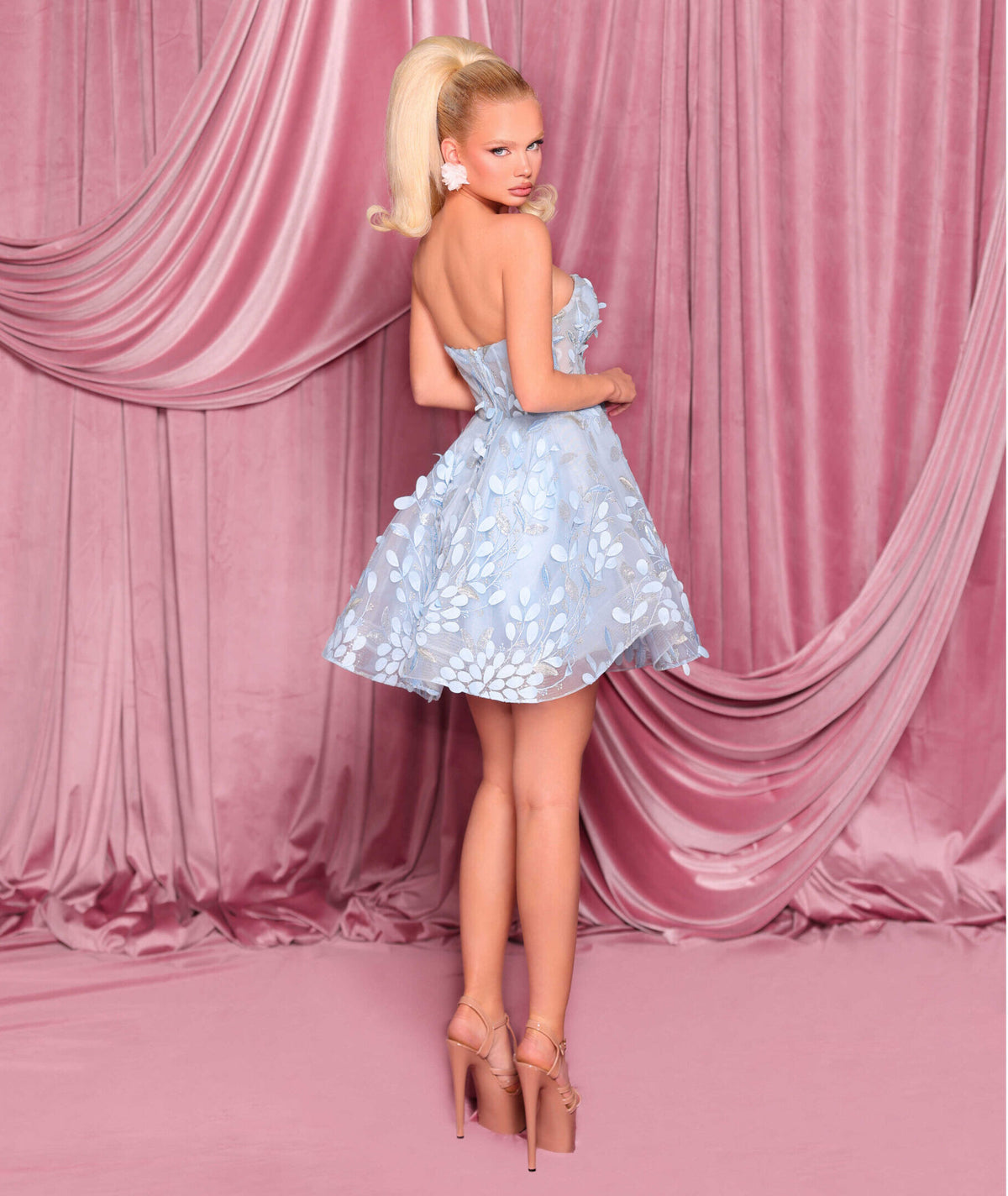 Model wearing Nicoletta NC3086 strapless mini dress with floral embroidery and flared skirt.