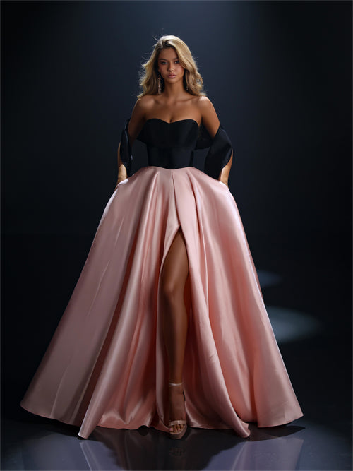 Model wearing Nicoletta NC4042 strapless ball gown with full overskirt and front slit.
