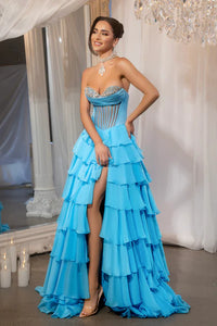 Model wearing Portia & Scarlett PS25961 gown featuring a strapless embellished bodice, sheer corset, high slit, and tiered ruffle skirt.