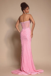 Woman wearing a pink strapless gown with intricate detailing on a beige background