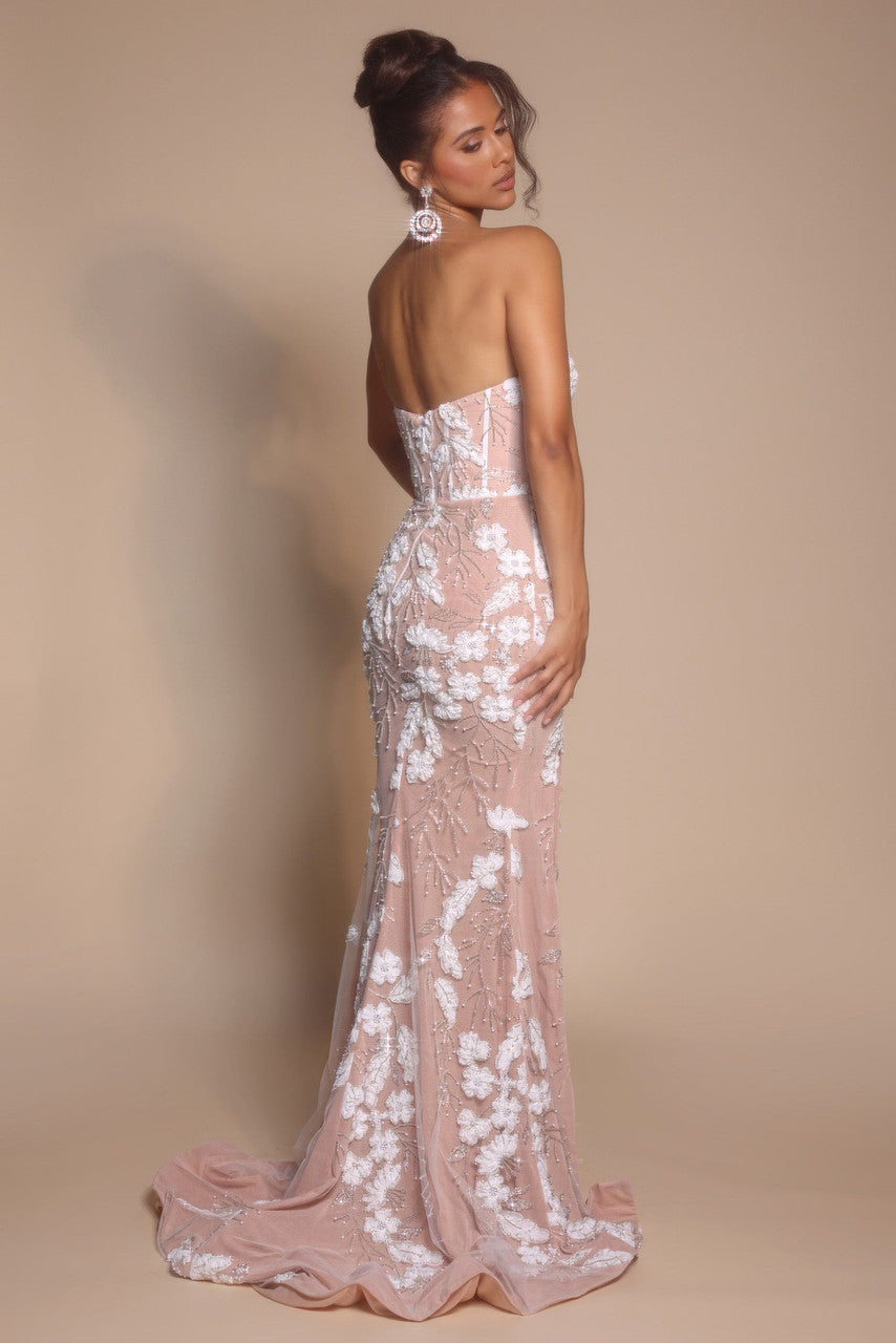 Model wearing Portia & Scarlett PS26074 strapless gown featuring floral appliqué detailing, fitted silhouette, high slit, and floor-length train.