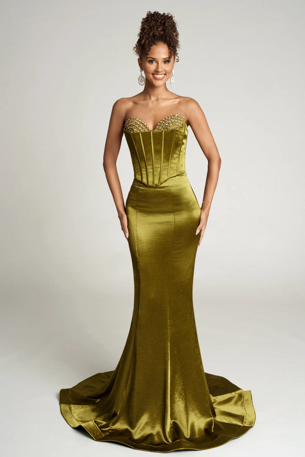 Woman wearing a strapless green evening gown with beaded details on a white background