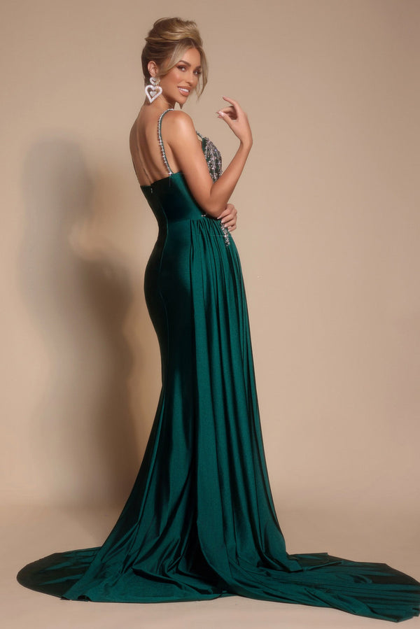 Woman wearing a green evening gown with a plain background