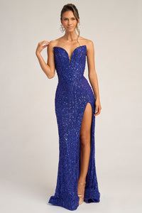 Woman wearing a cobalt blue sequin evening gown with a slit on a white background