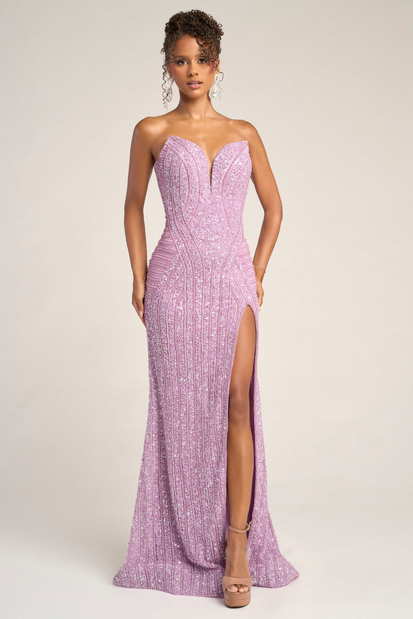 Woman wearing a strapless, high-slitted purple evening gown on a plain background