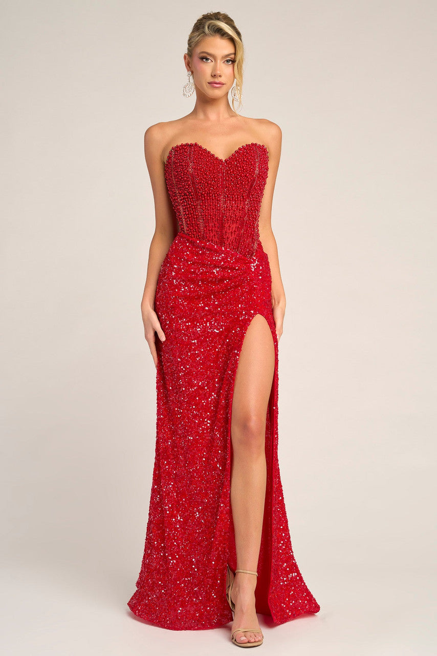 Red strapless evening gown with a high slit on a plain background