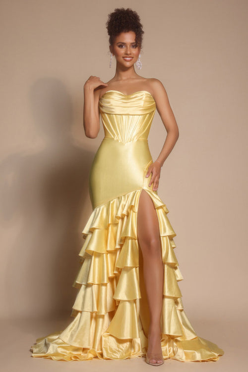 Woman wearing a yellow strapless gown with ruffled skirt on a beige background