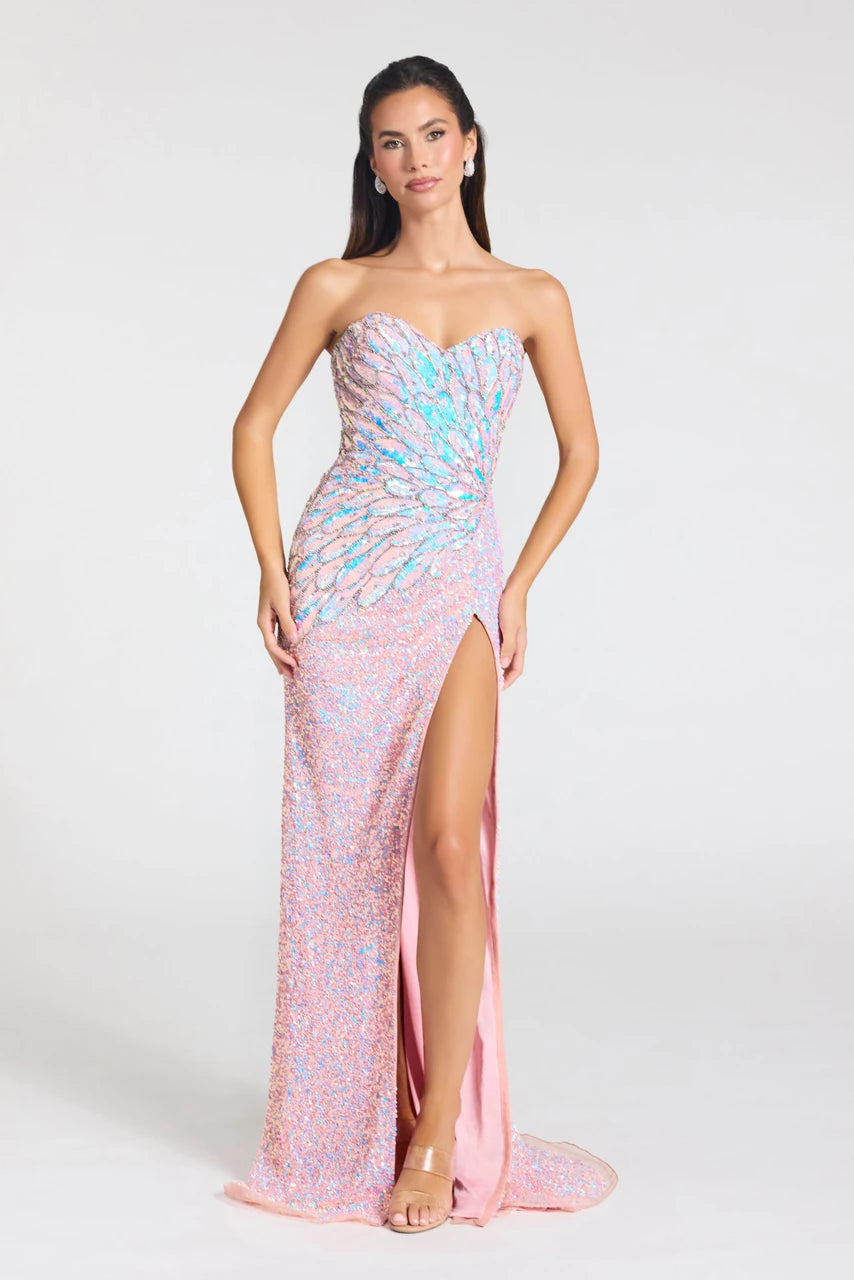 A woman models a strapless, floor-length pink gown covered in iridescent sequins with a sweetheart neckline, ruched bodice, high thigh slit, and a small train on a light gray studio background.