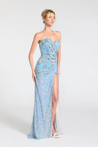 A woman modeling a strapless light blue sequined evening gown with a sweetheart neckline, ruched bodice, high thigh slit, and floor-length train against a plain light gray studio background.